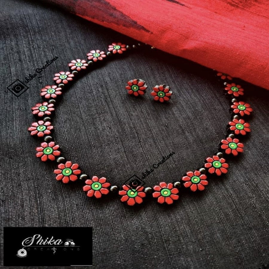 TERRACOTTA FLOWER NECKSET WITH STUDS. COLOURS: GOLD, RED, BLACK AND GREEN.